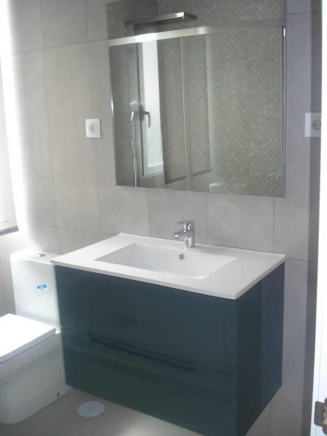 Baño renovado con mueble suspendido y espejo grande instalado por ABC Decoración y Reformas