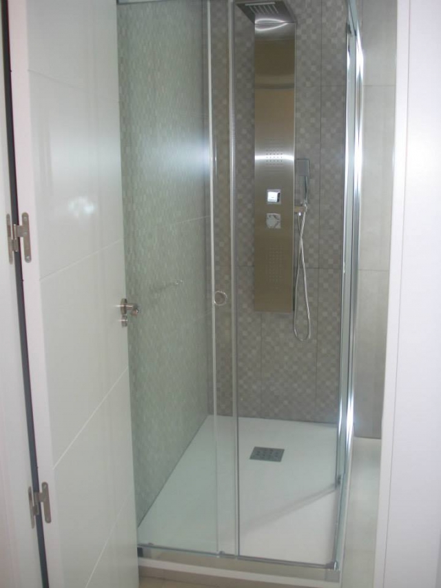Ducha moderna con mampara transparente instalada en reforma por ABC Decoración y Reformas.